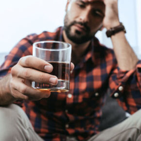man holding a glass of whiskey