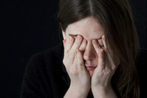 woman holding her palms over her face