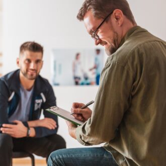 doctor taking notes during a therapy session